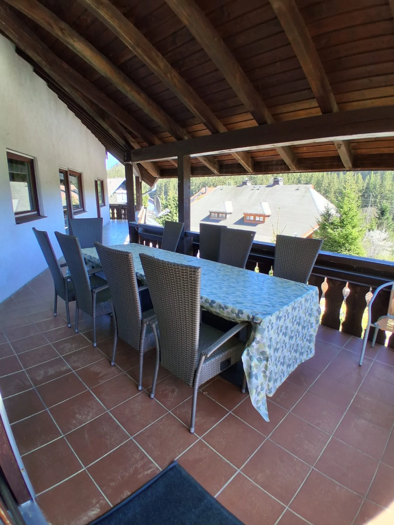 Großer überdachter Balkon mit langer Tafel