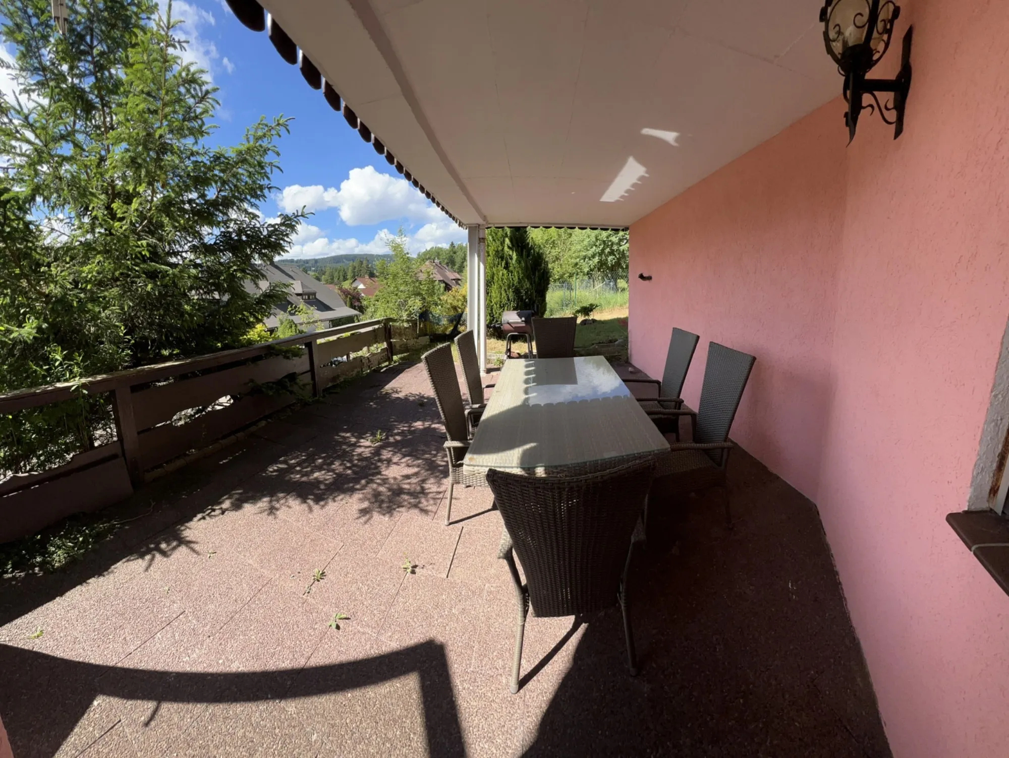 Überdachte Terrasse mit Esstisch und Ausblick